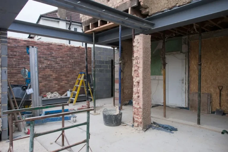 House renovation with new steel beams and temporary props supporting a knock-through into a rear extension
